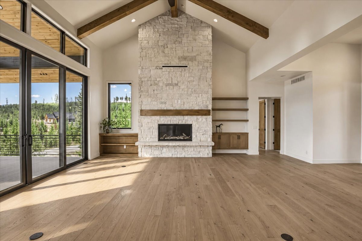 great room stone fireplace with Alderwood stained mantle, flanked by built-in shelves and cabinets