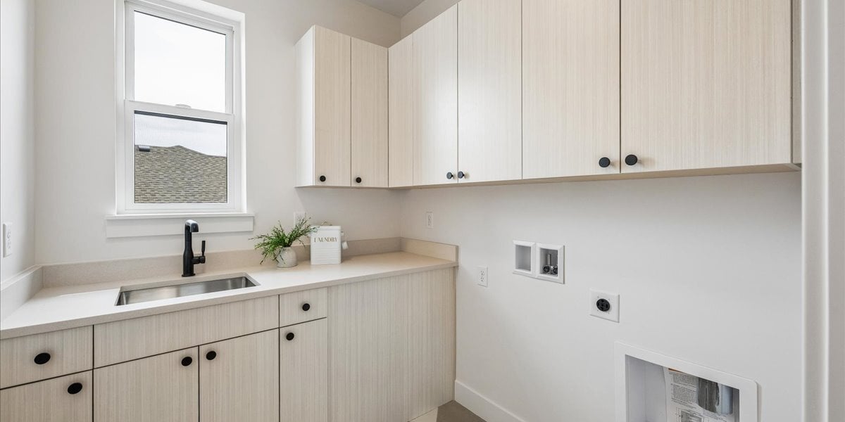 laundry room with cabinets and utility sink