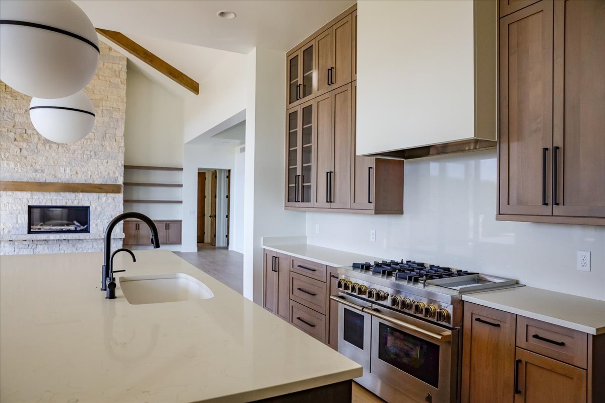 high-end gas range-cooktop and custom hood, as seen from the kitchen island