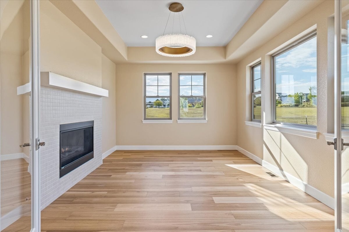 light-filled dining room with fireplace and stylish pendant light fixture