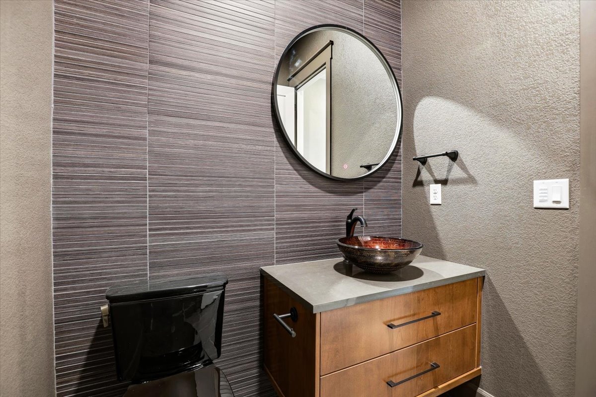 Plan #3964 - main-floor powder bath with tiled wall and black toilet