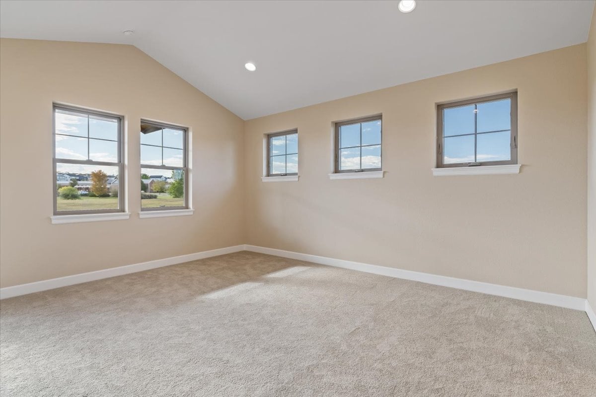 primary suite with vaulted ceiling and abundant window light