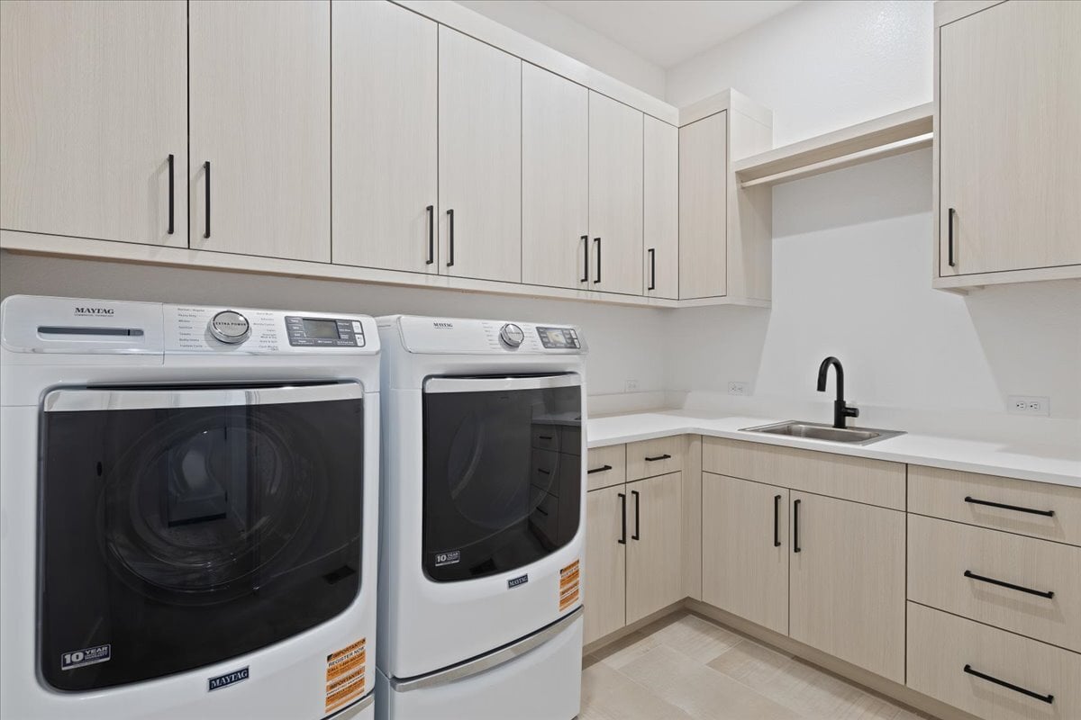 laundry room with cabinets and sink
