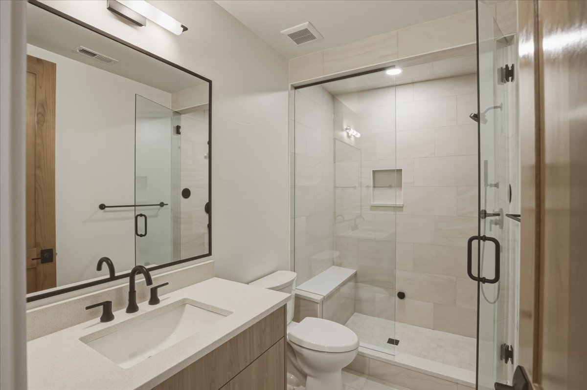 secondary bath with tiled shower and single vanity