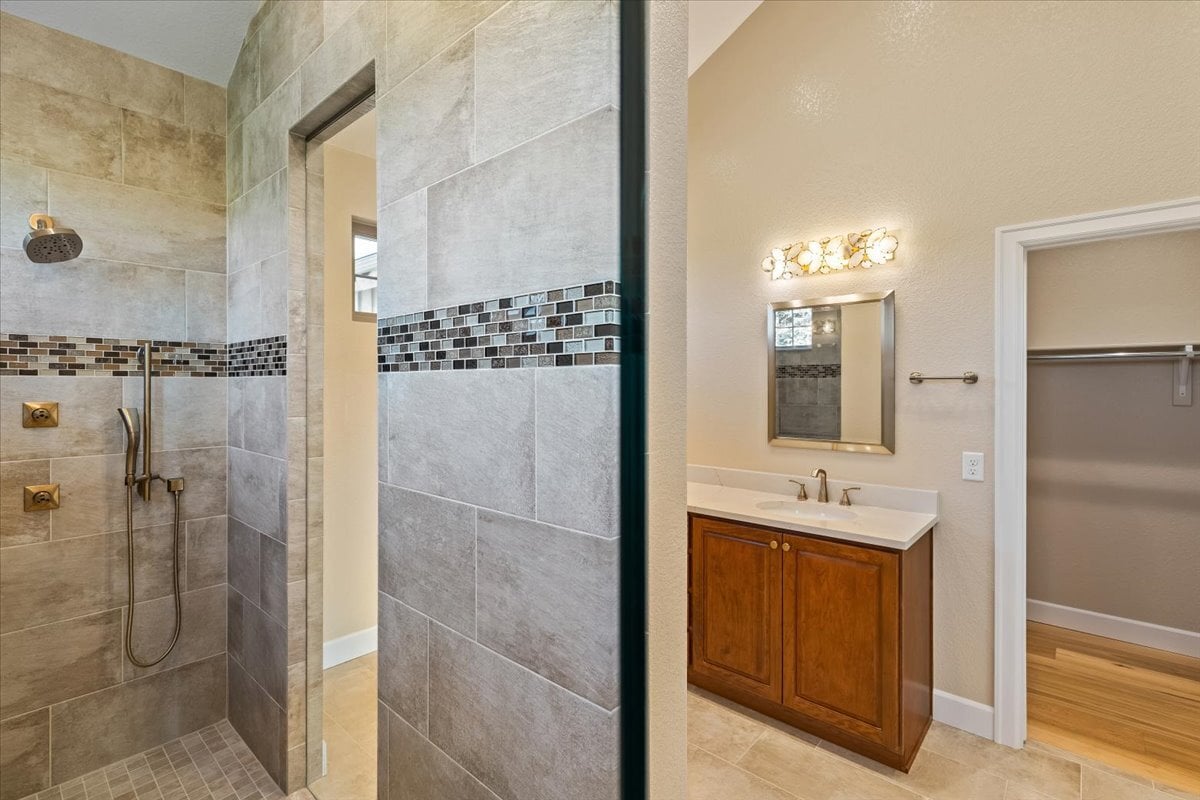 view from primary walk-in shower to vanity area