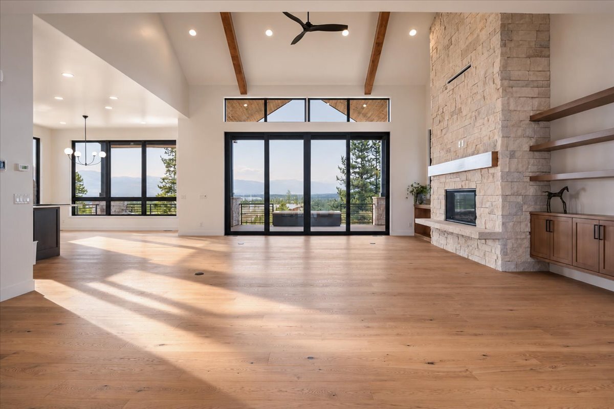 main-floor great room of large mountain retreat with hardwood flooring and fireplace