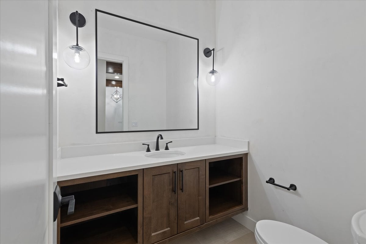 secondary bath with open shelving and custom lighting