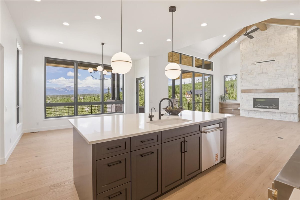 view of great room from large kitchen island, facing large windows with mountain views