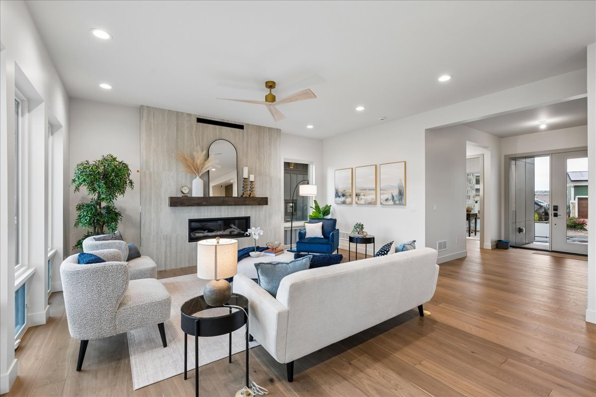 an open great room with hardwood flooring and a statement fireplace