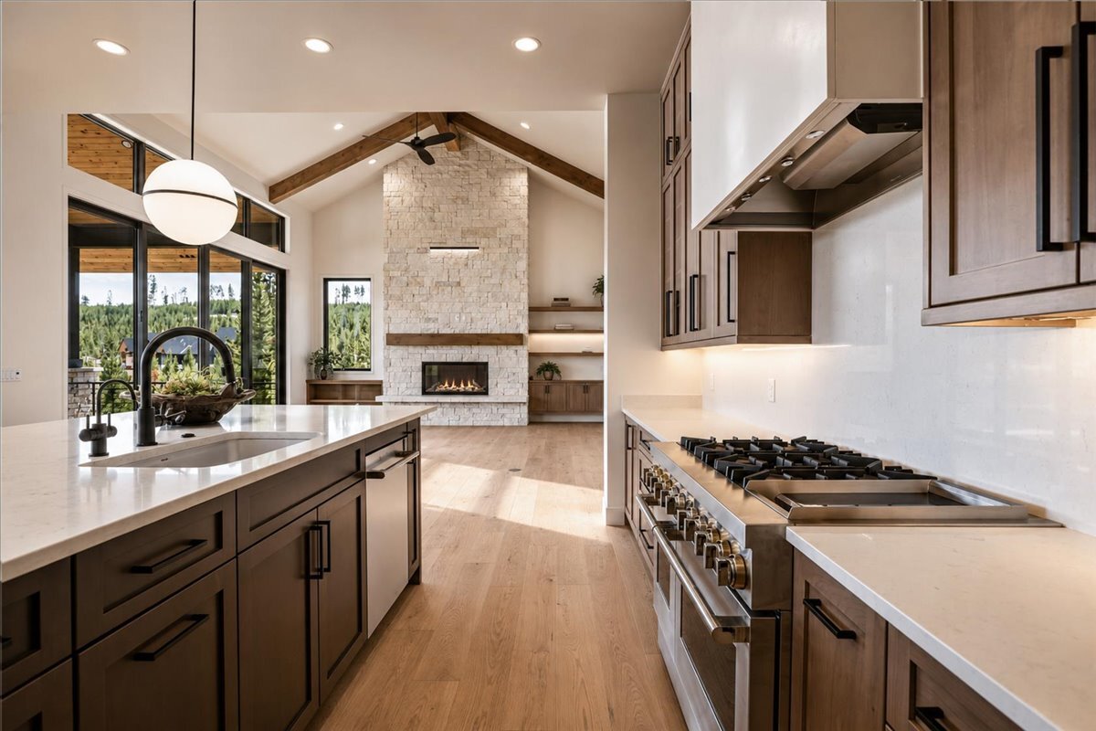 a sunlit kitchen with view to the great room fireplace