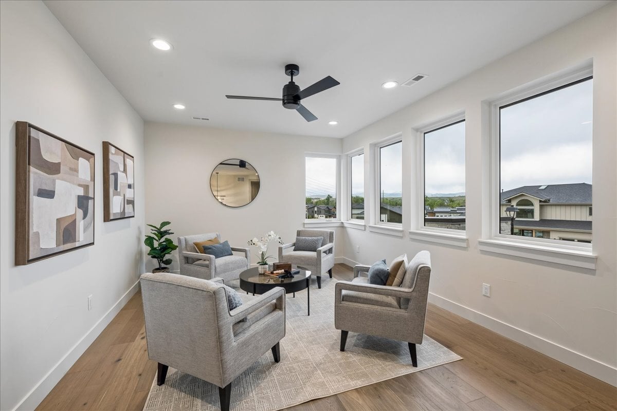 light-filled 2nd-story loft seating area with hardwood flooring and large windows