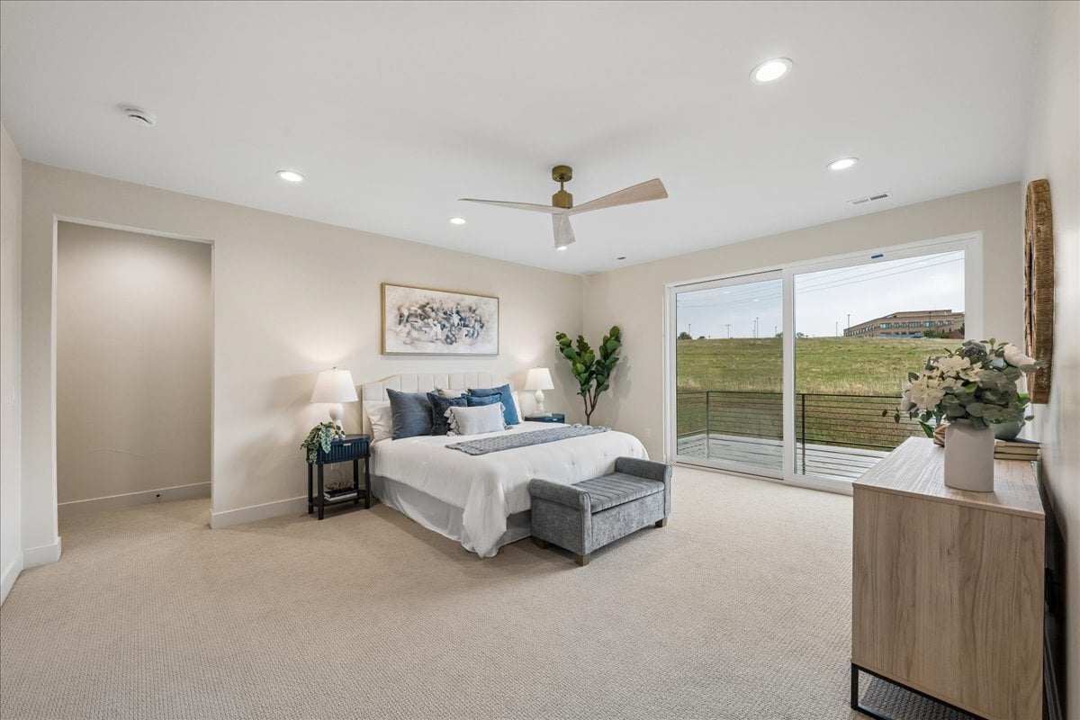 primary bedroom suite with deck access, king-sized bed, side tables, and other furnishings