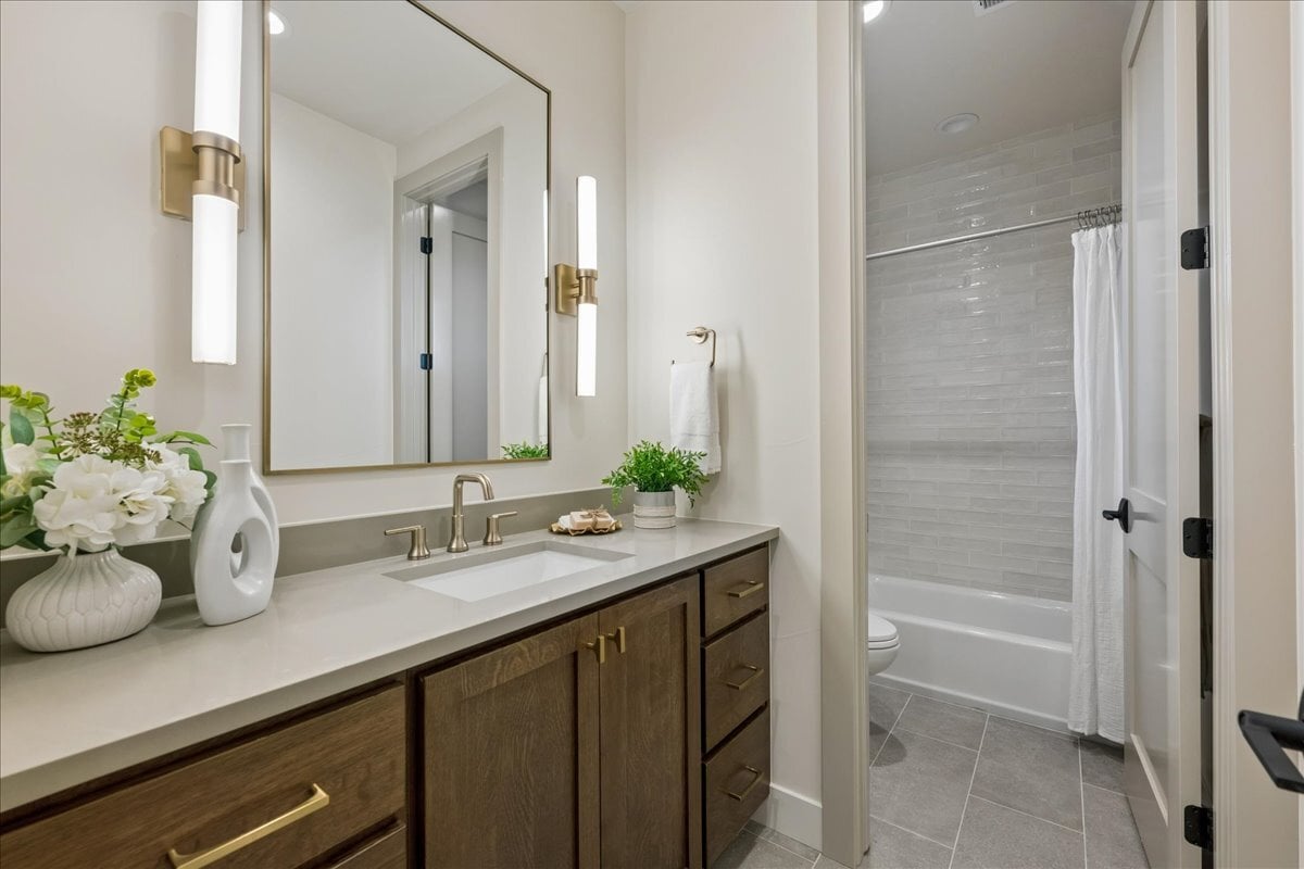 secondary upper-floor bathroom with long single vanity and private toilet/shower area