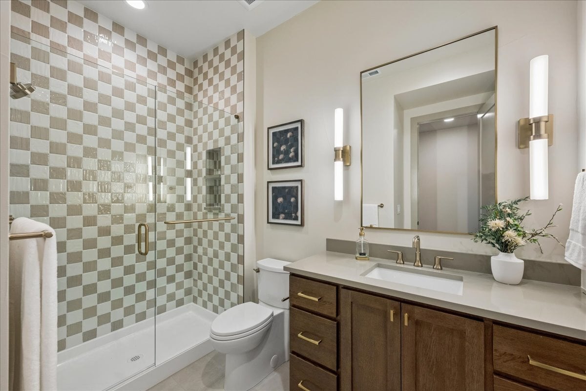 basement bathroom with checked tile shower and single vanity