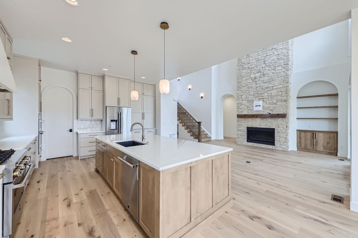 Open-concept kitchen with high-end finishes and a spacious layout in a Westminster, CO, custom home by Sheffield Homes