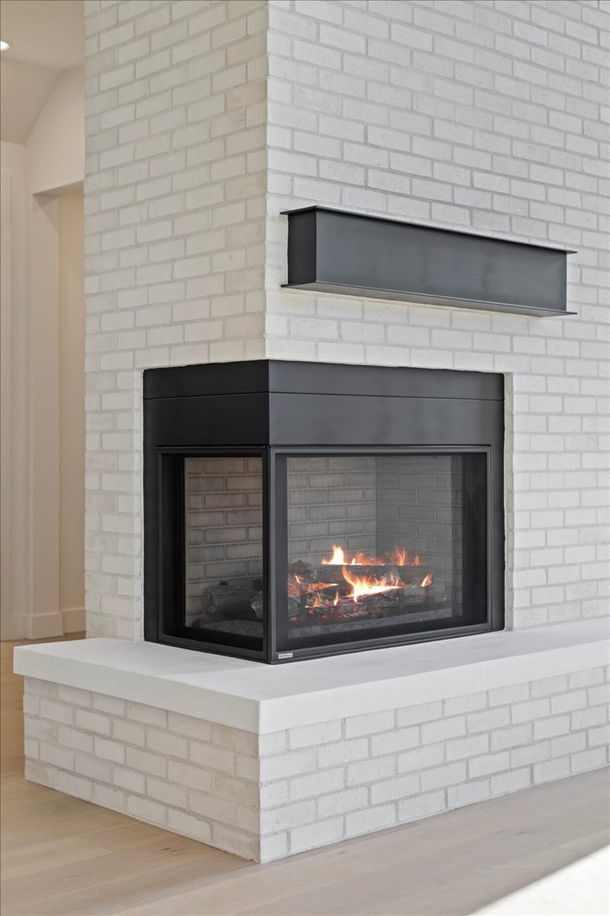 Close-up of a modern white brick fireplace with black accents in a Denver, CO luxury custom home.