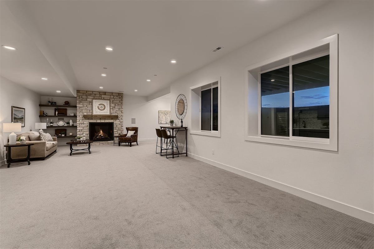 Spacious lower-level basement with carpet flooring and a sitting area in a custom home by Sheffield Homes in Franktown, CO
