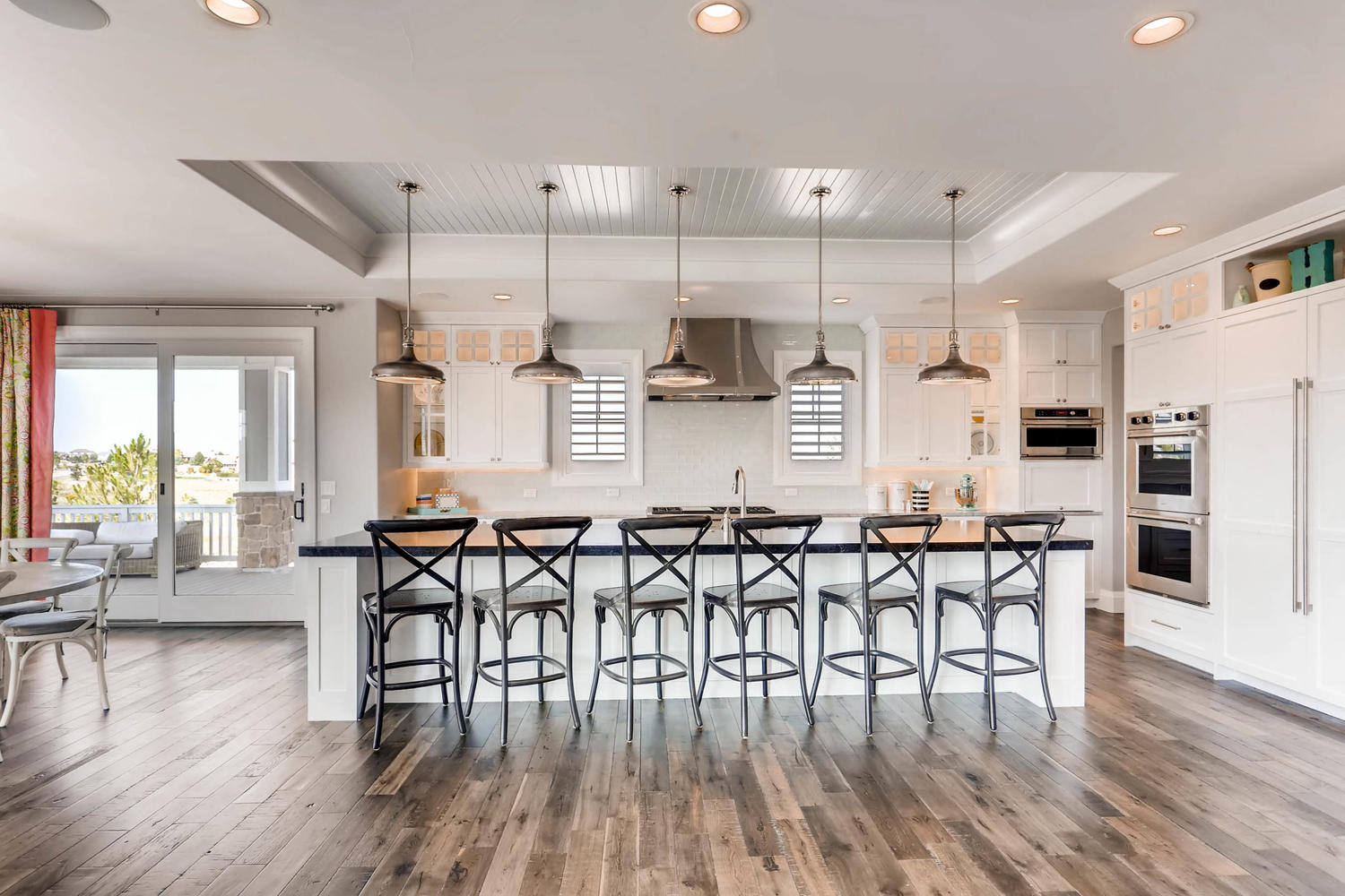 Kitchen facing view with seating and elegant lighting in a custom home by Sheffield Homes in Parker, CO