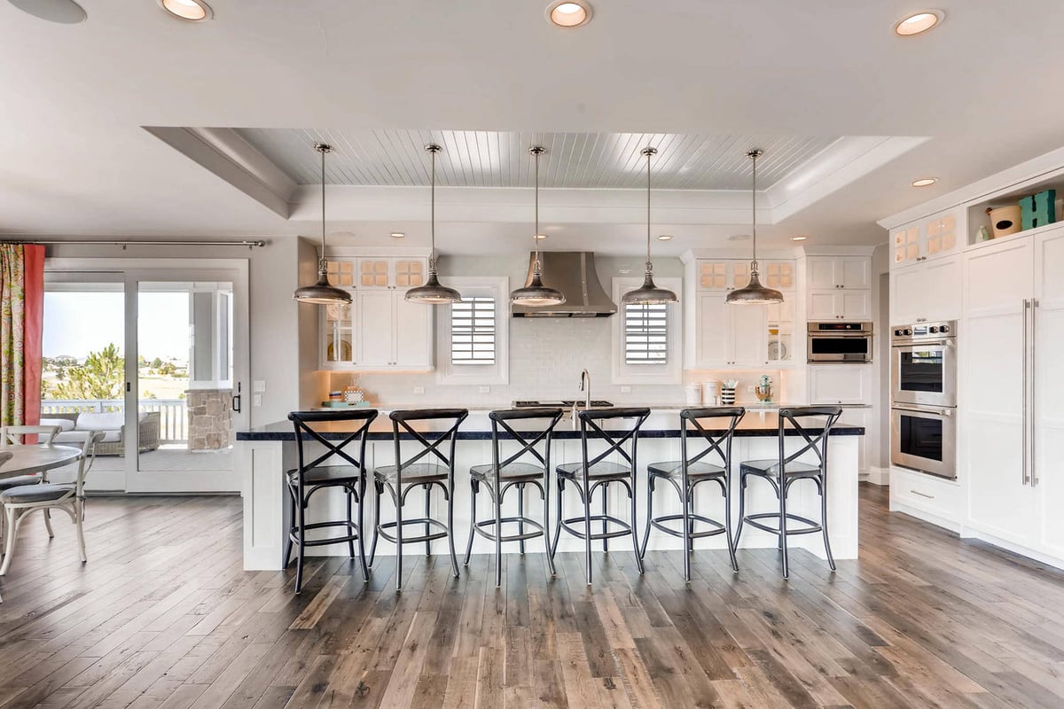 Kitchen facing view with seating and elegant lighting in a custom home by Sheffield Homes in Parker, CO
