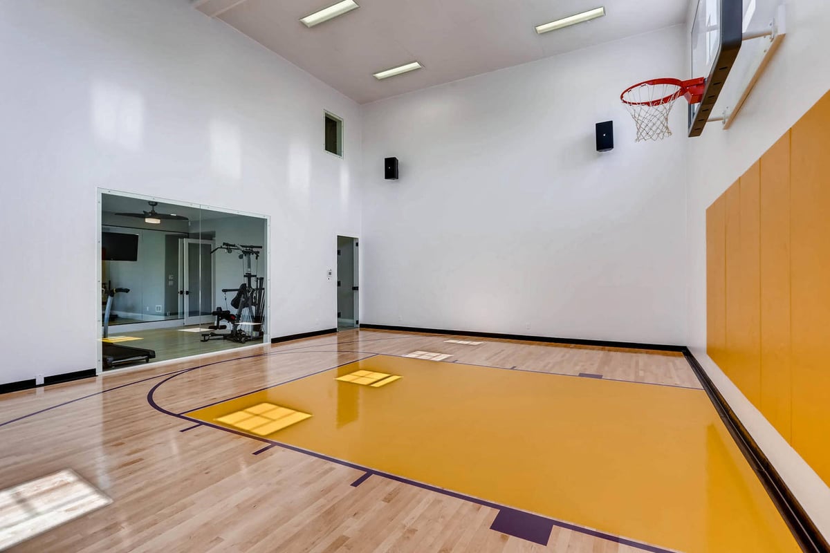 Lower-level recreation room with a mini basketball court and a home gym in front in a Sheffield Homes home in Parker, CO