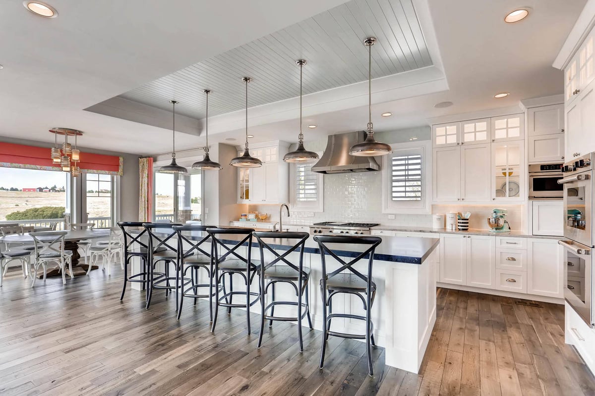 Modern open-concept kitchen with a central island and seating area in a large custom home by Sheffield Homes in Parker, CO