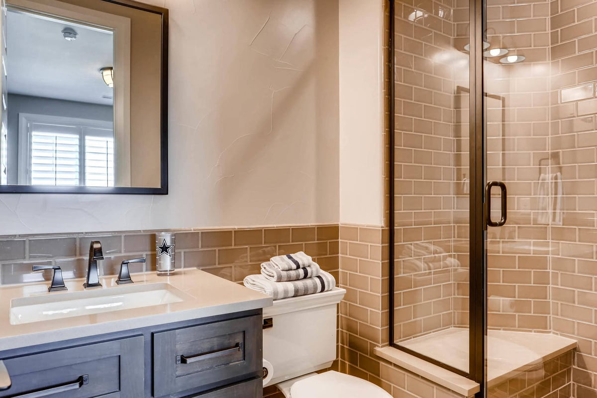 Second-floor bathroom with a single vanity, a toilet, and a glass-enclosed shower area in a Sheffield Homes home, Parker, CO
