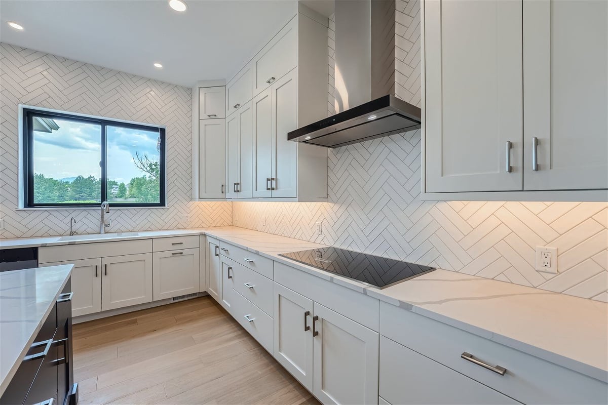 Kitchen cabinetry with a central counter space and an electric stove fixture in a Sheffield Homes custom home, Superior, CO