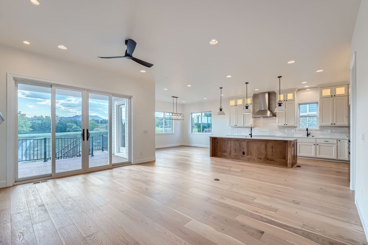 Modern living room in a custom home by Sheffield Homes in Denver, CO, with large windows and hardwood flooring