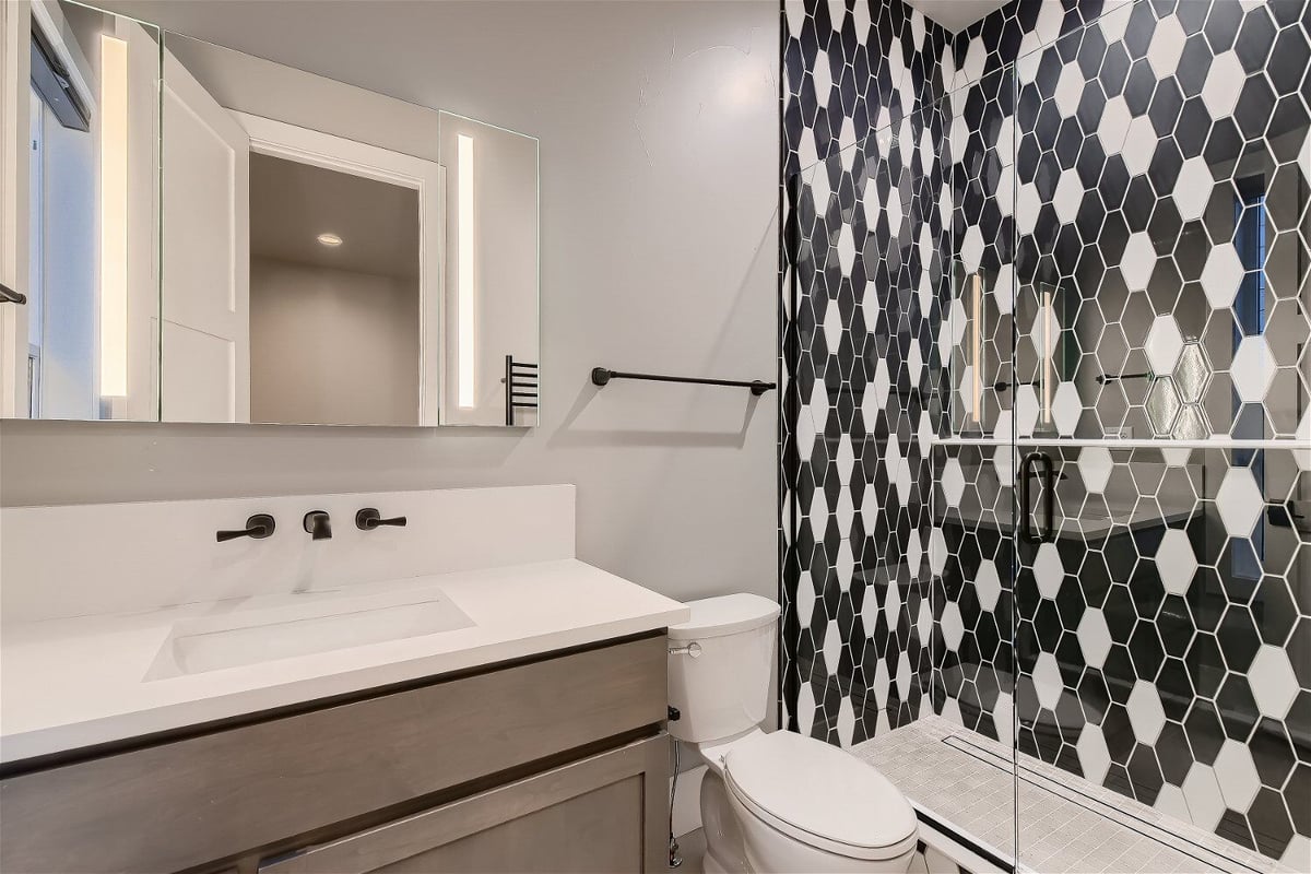 Modern bathroom with black-and-white tile shower in a Sheffield Homes custom home, Denver, CO