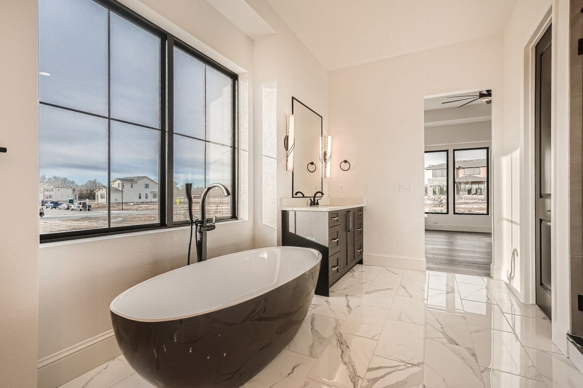 Bathroom of a brown and white color theme, featuring a cocoa-shaped bathtub and a vanity, by Sheffield Homes, Westminster, CO