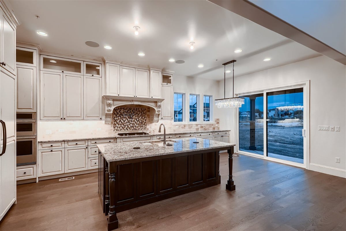 Kitchen featuring a vintage-style island, modern cabinetry, and elegant lighting, by Sheffield Homes in Westminster, CO