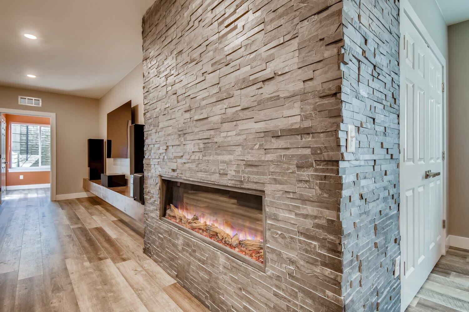 Basement fireplace with stone accent wall by Sheffield Homes in Denver, CO
