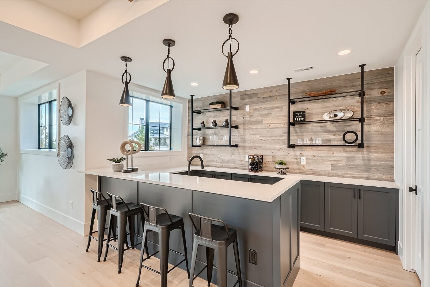 Basement kitchen with black cabinetry and industrial lighting, part of Sheffield Homes remodel in Franktown, CO