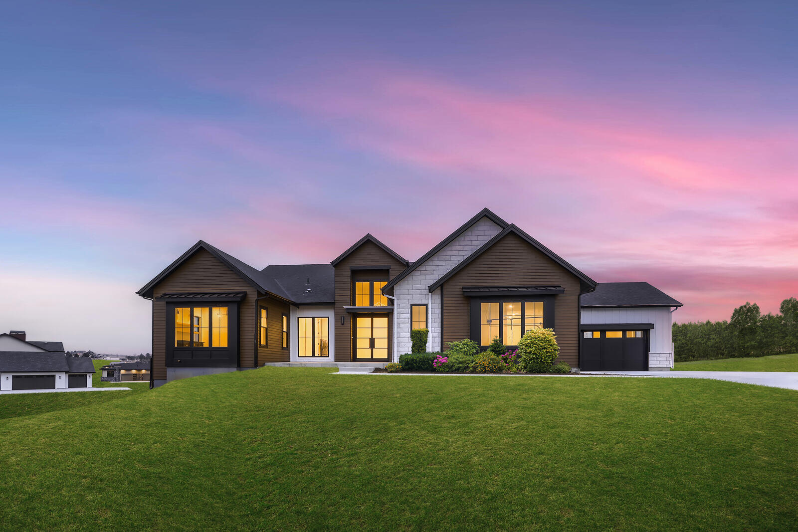 Front view of a custom-built home by Sheffield Homes in Denver, CO, showcasing a beautiful lawn and modern architectural details at sunset Front view of a custom-built home by Sheffield Homes in Denver, CO, showcasing a beautiful lawn and modern architectural details at sunset