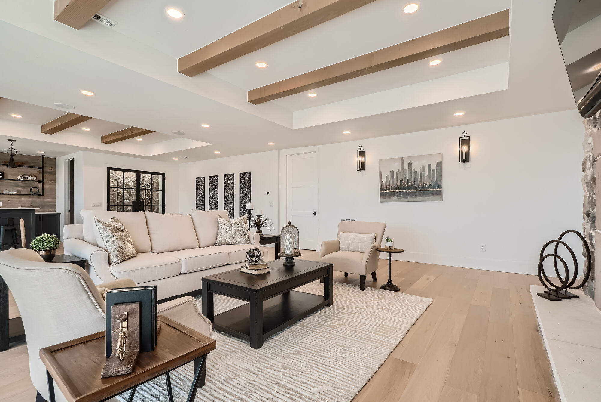 Custom-built family room with exposed wooden beams and neutral decor by Sheffield Homes in Arvada, CO