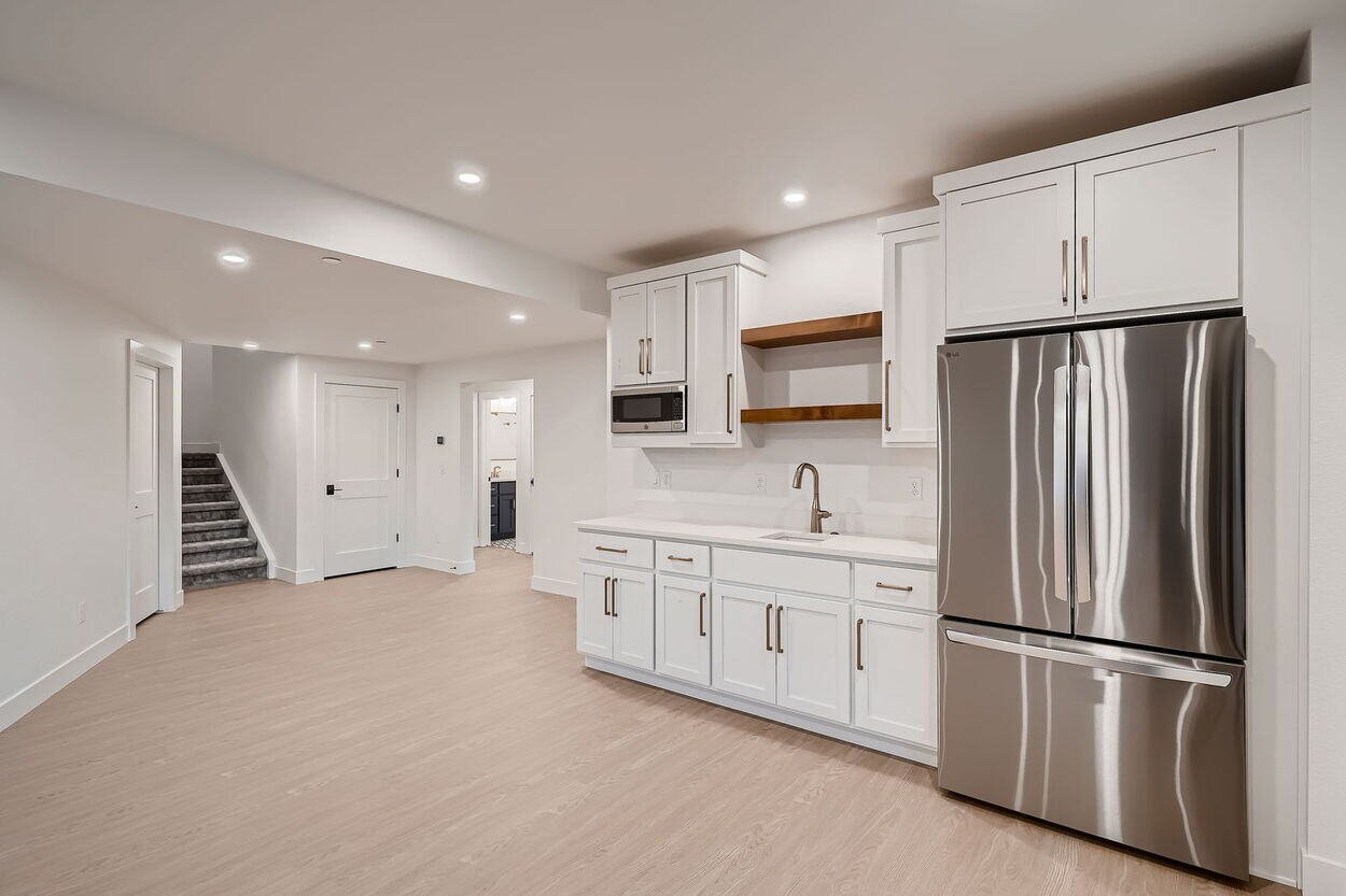 Basement kitchenette featuring open shelving and sleek design in custom home by Sheffield Homes in Denver, CO