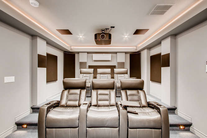 luxe basement theater room with surround sound and tiered seating
