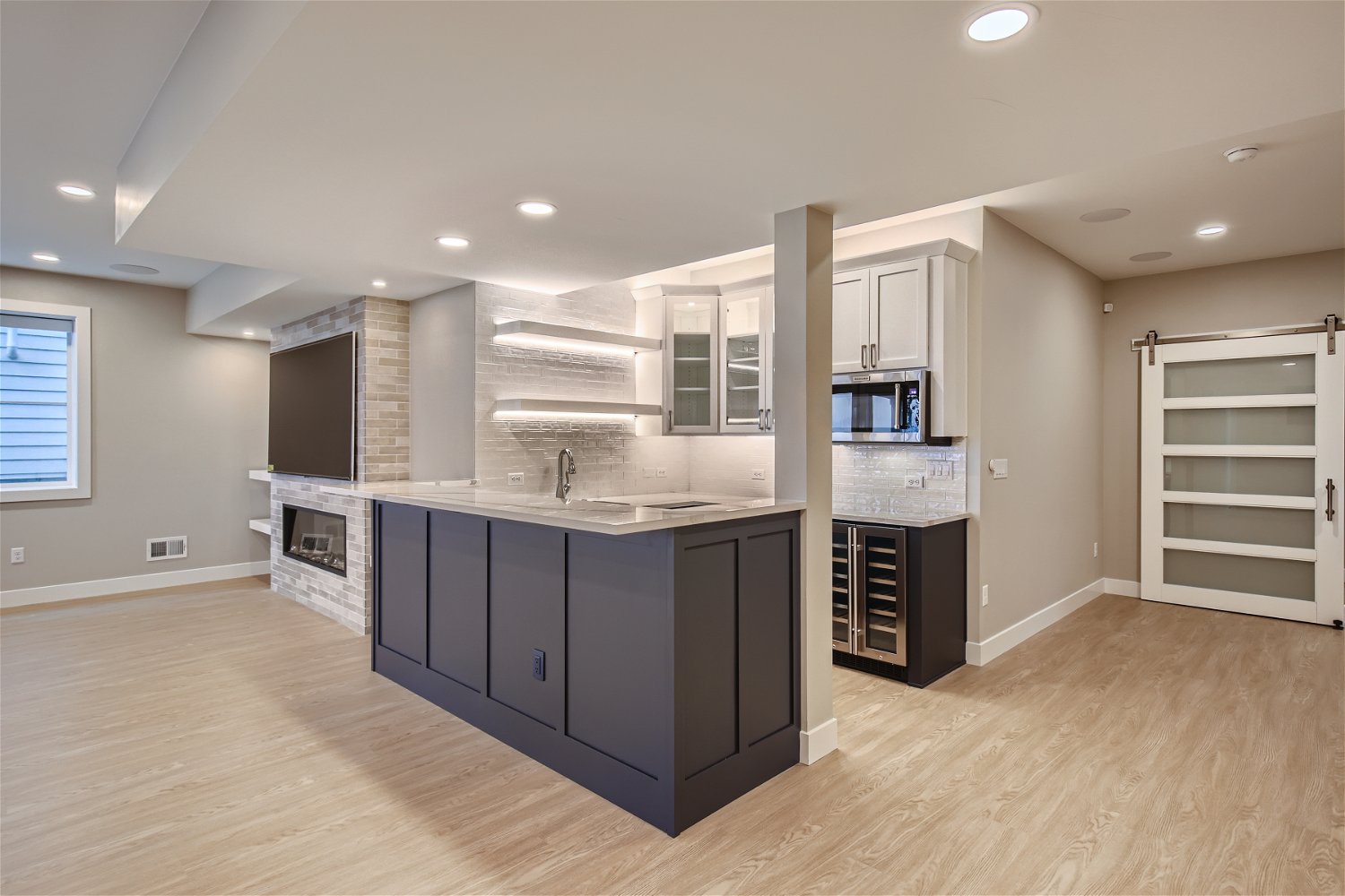 upscale basement wetbar and entertainment area, with fireplace