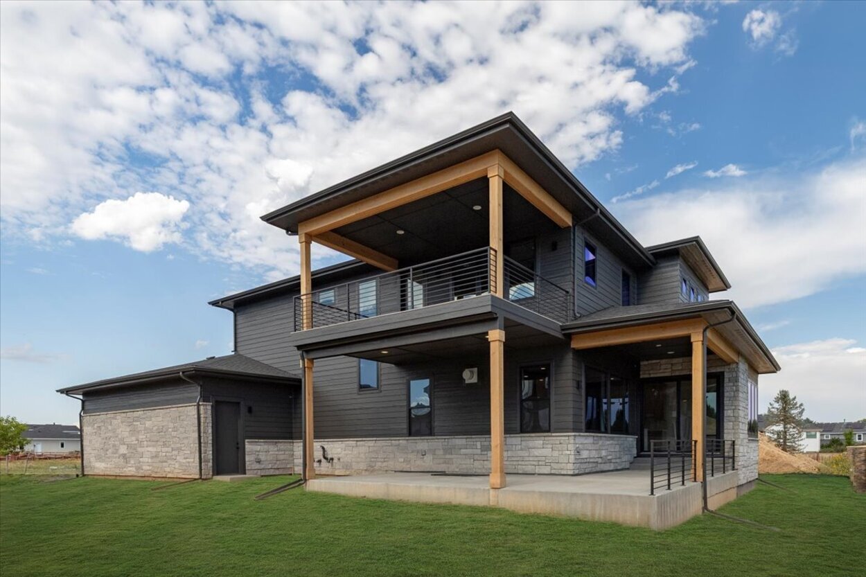 Rear corner view of luxury spec home in Denver, CO with covered second-floor balcony Rear corner view of luxury spec home in Denver, CO with covered second-floor balcony
