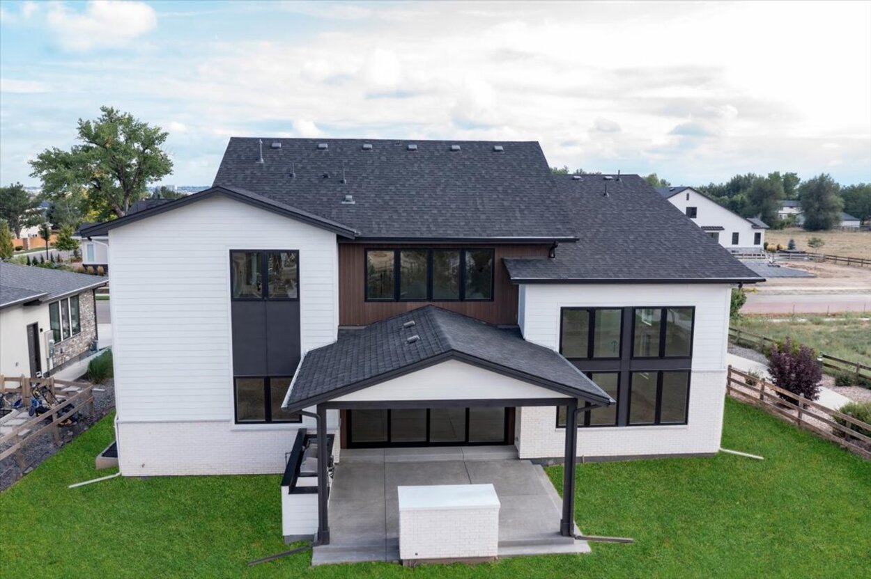 Rear exterior of a custom luxury home in Denver, CO showcasing open yard and structural elegance Rear exterior of a custom luxury home in Denver, CO showcasing open yard and structural elegance