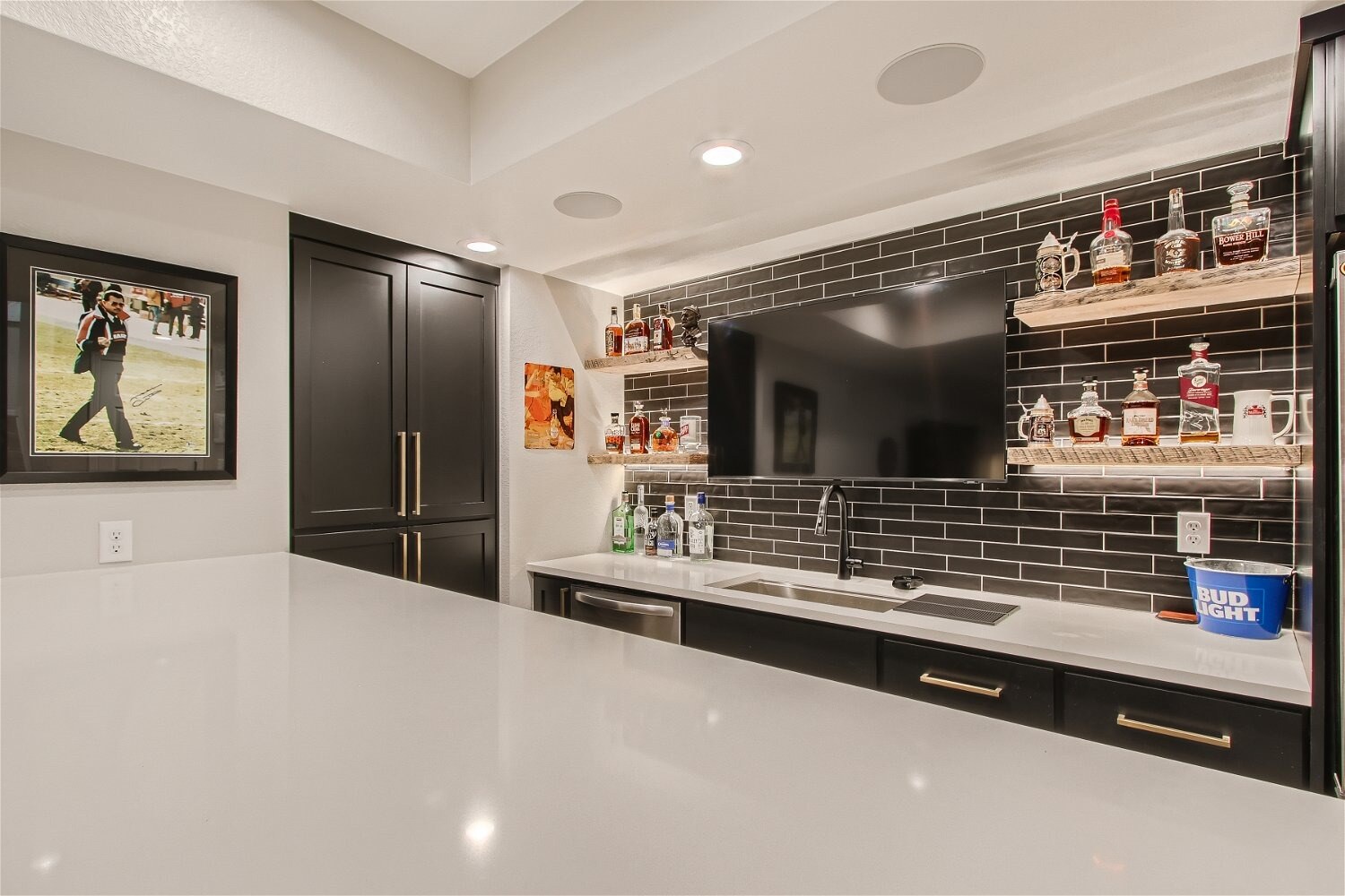 Stylish basement wet bar with black brick backsplash, part of a Sheffield Homes basement finishing in Arvada, CO