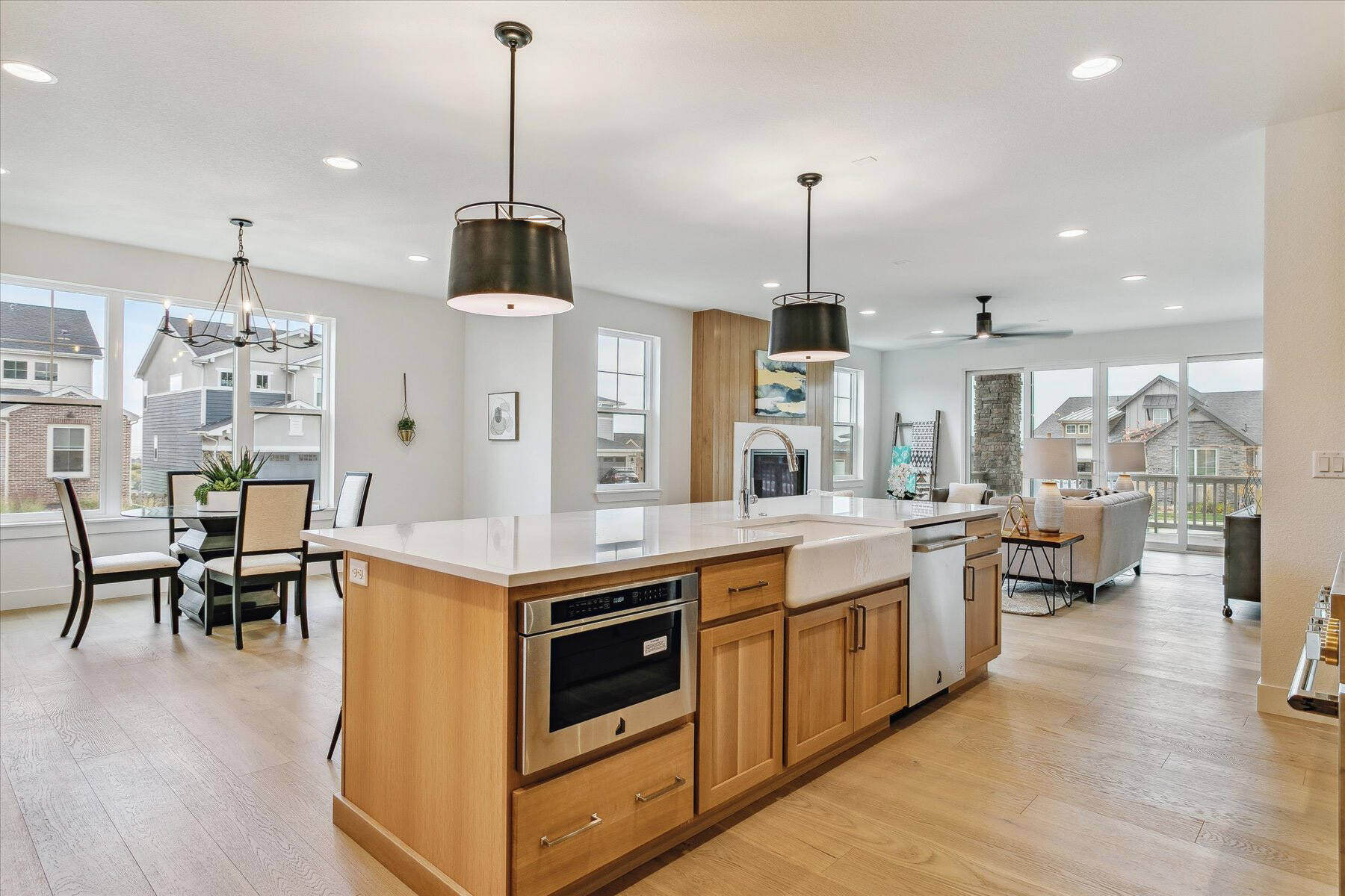 Modern kitchen detailing with hanging lamps and a mini dining table in the background by Sheffield Homes in Arvada, CO