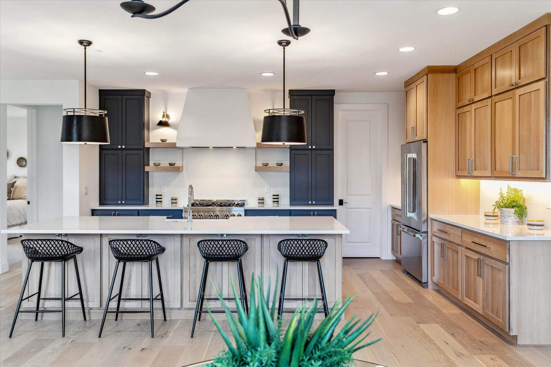 Open kitchen with a beautiful island, dining seats, and sleek cabinetry in a custom home by Sheffield Homes in Arvada, CO