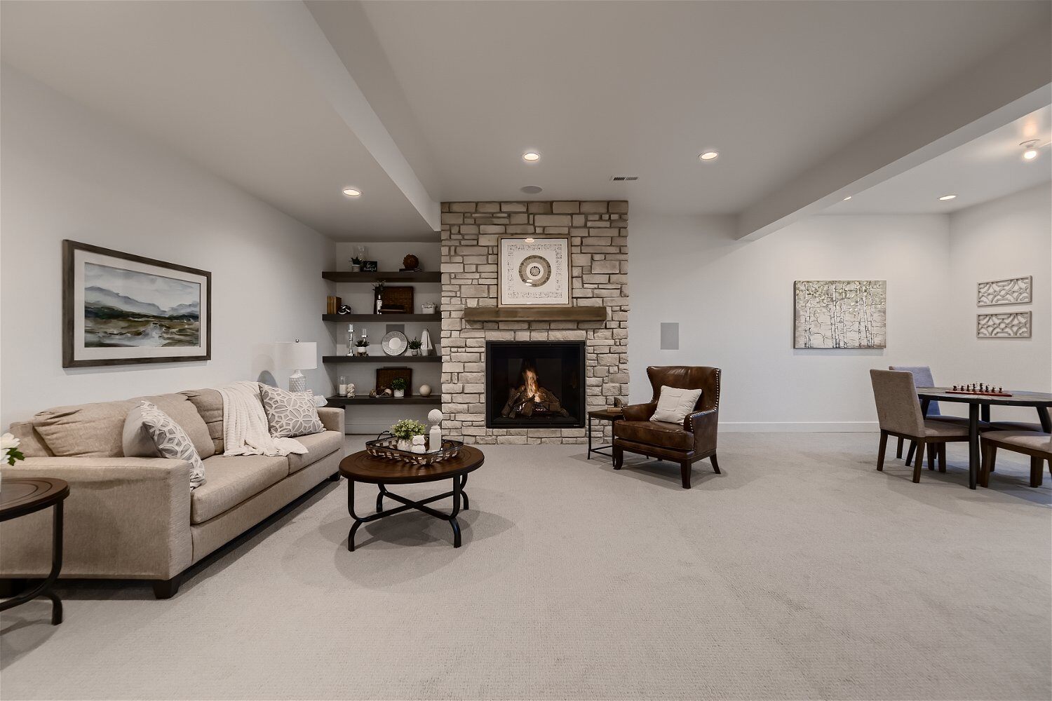 Lower level basement with sofa sets and a wall-mounted fireplace in a custom home by Sheffield Homes in Franktown, CO