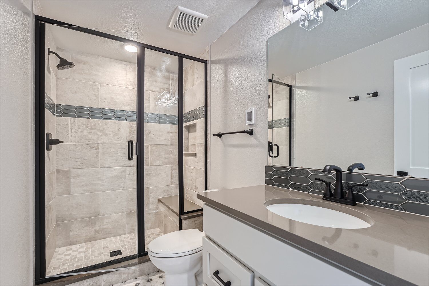 Lower-level bathroom with a wash basin sink, a toilet seat, and a shower room in a Sheffield Homes home in Superior, CO