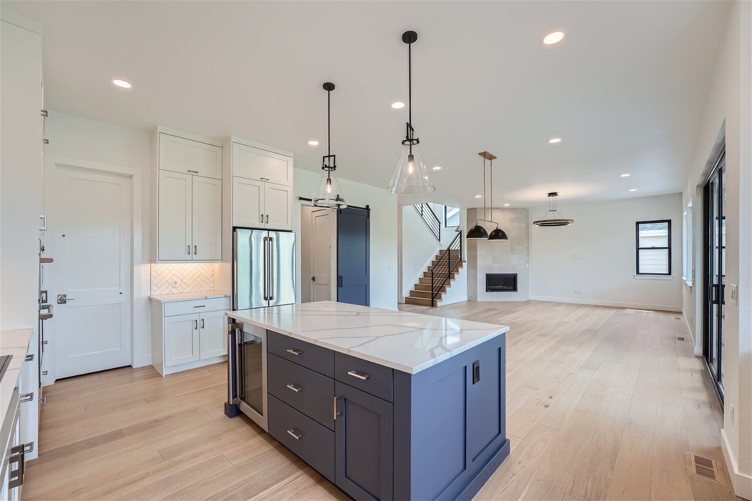 Premium kitchen island with a sleek countertop and pendant lighting above it in a Sheffield Homes custom home, Superior, CO