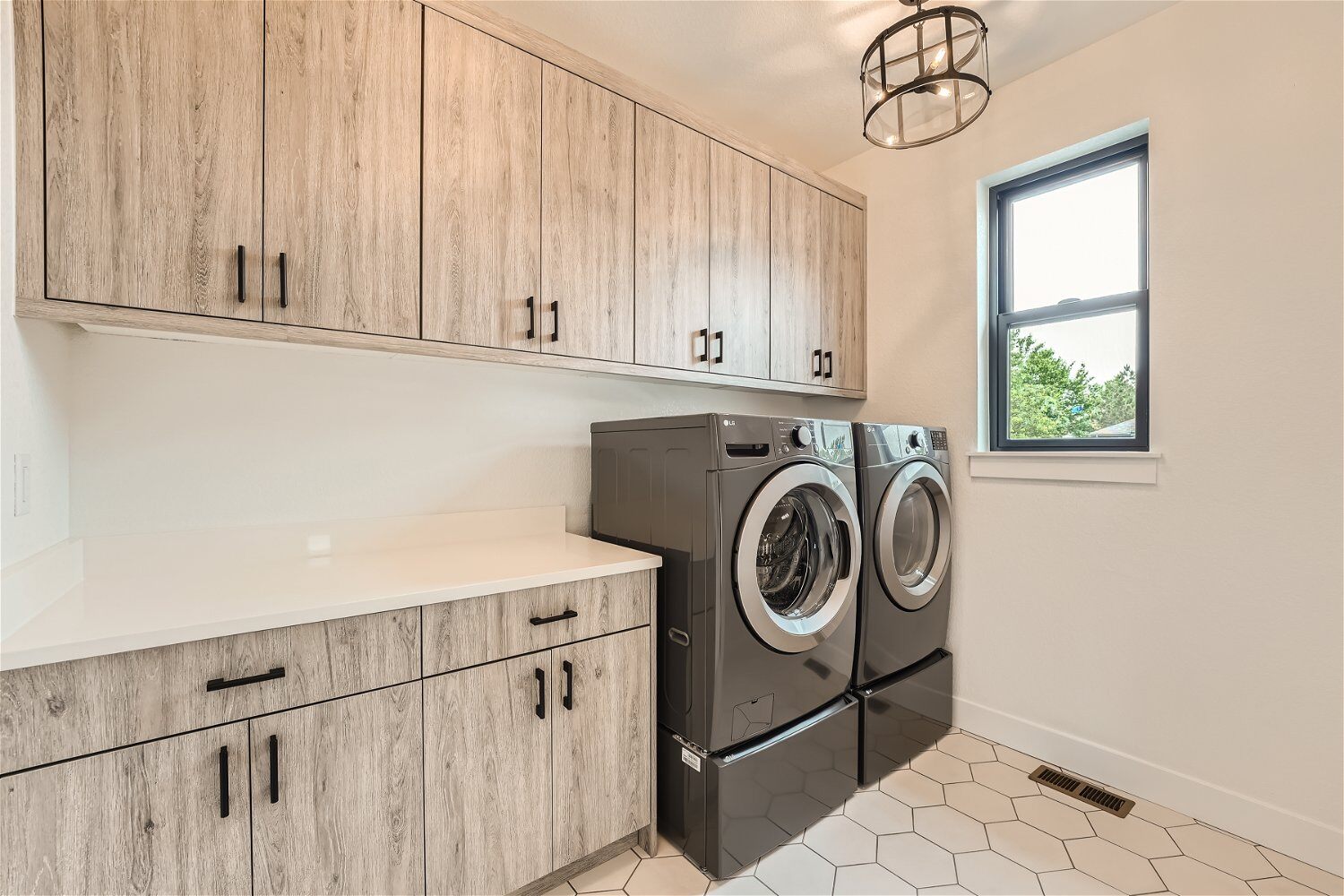 Second-floor laundry room with washing machines and wooden cabinetry for storage in a Sheffield Homes home in Superior, CO