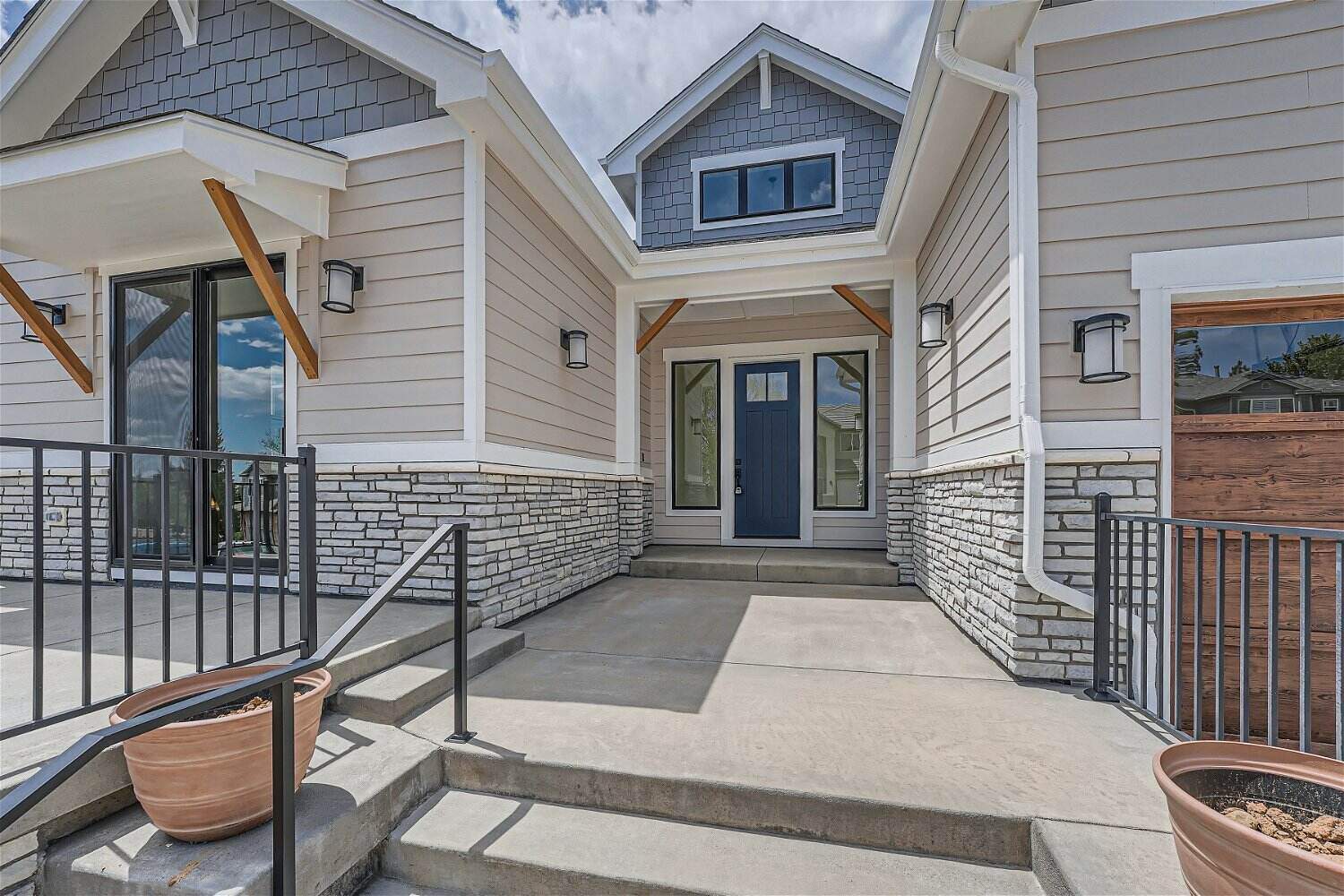 Exterior front entrance of a custom home with a paved pathway leading to the main door, by Sheffield Homes in Superior, CO