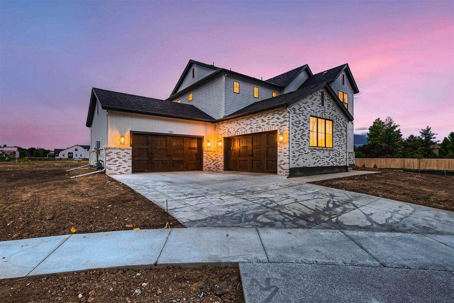 Exterior side-front view of a custom home with a garage and paved driveway, by Sheffield Homes in Westminster, CO